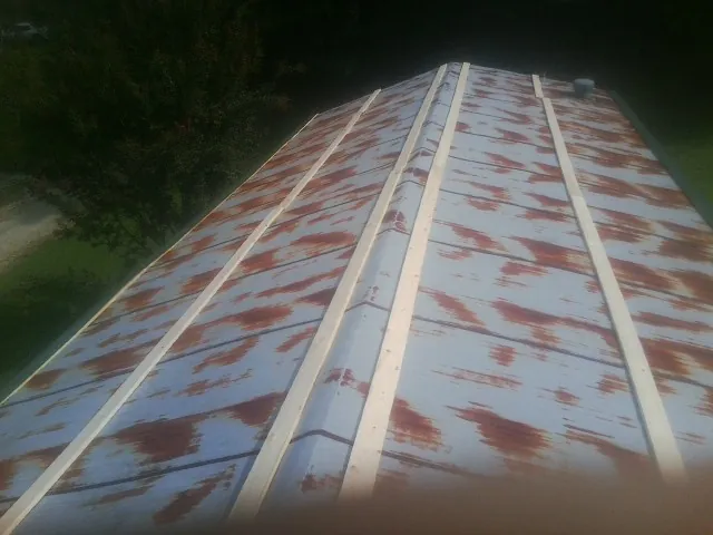 Rusted metal roof panels with new wood purlins before replacement — Storm Damage Roof Repair in Maxwell by Roofing Brothers
