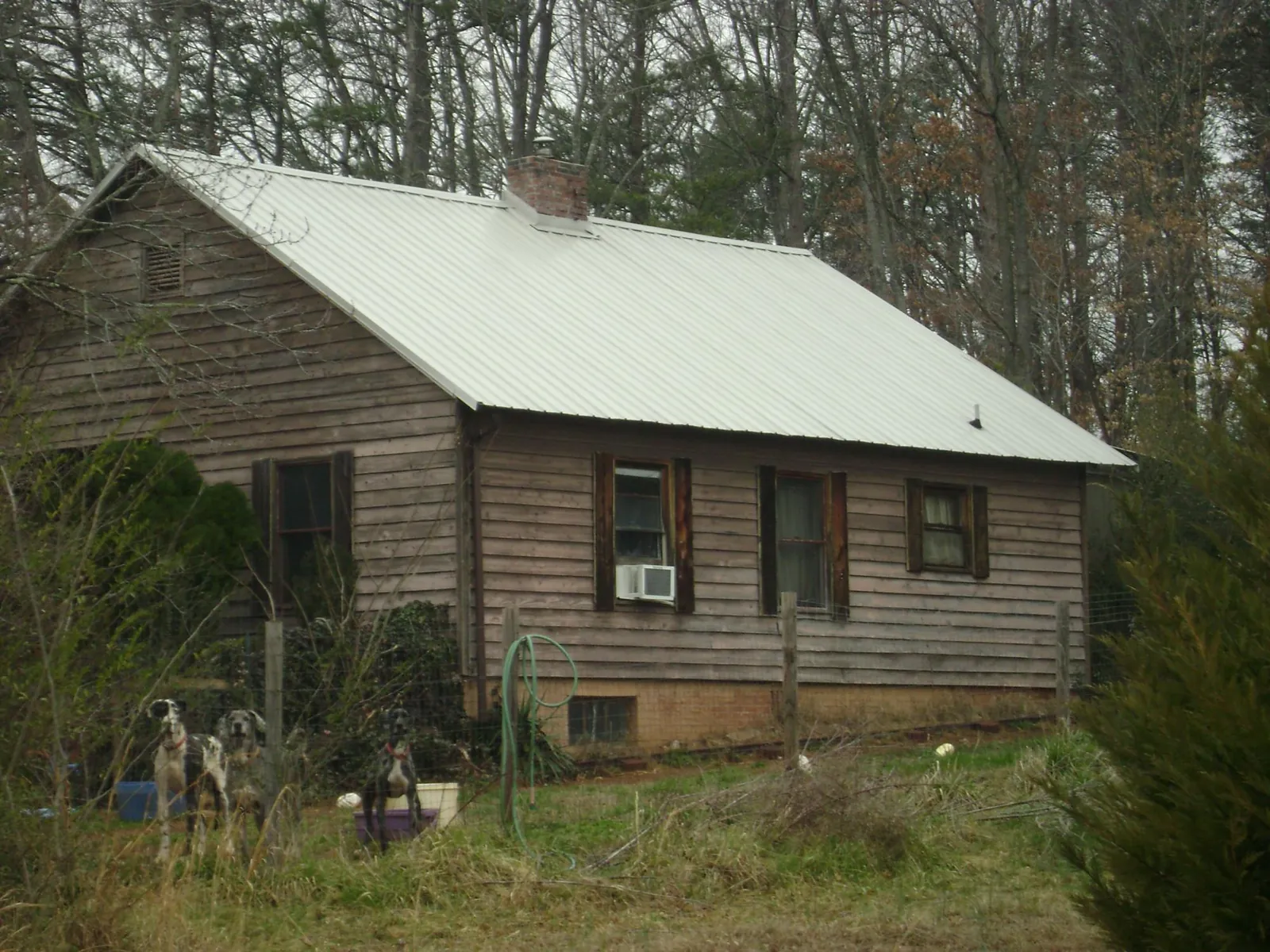 White metal roof on an old wood sided farmhouse, from a Metal Roof Installation job in Maxwell
